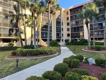 Beautiful multi-story condo building with tropical landscaping and palm trees along the walkway at 3006 Caring Way # 409, Port Charlotte, FL 33952
