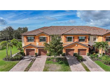 Beautiful townhome exterior showcasing a tile roof, brick driveway, and a two car garage at 20272 Lagente, Venice, FL 34293