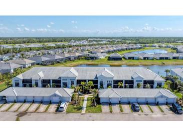 Stunning aerial view of the condominium complex with beautiful landscaping, pond, and community at 14184 Heritage Landing Blvd # 516, Punta Gorda, FL 33955