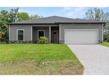 Charming single-story home featuring a two-car garage, well-maintained lawn, and welcoming front entrance at 1790 New London St, North Port, FL 34288