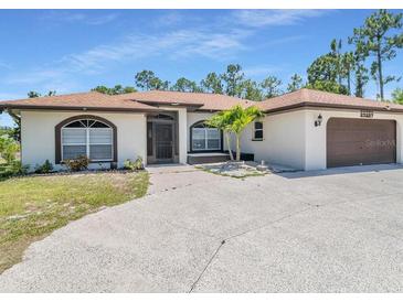 Charming one-story home with a well-maintained lawn and a two-car garage in a desirable neighborhood at 23227 Adela Ave, Port Charlotte, FL 33952