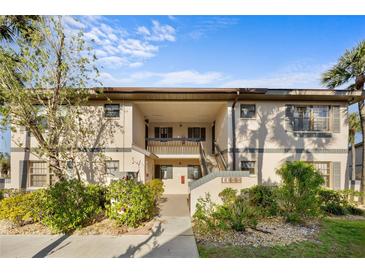 Inviting condo exterior with lush landscaping and covered walkways, offering a charming curb appeal at 19505 Quesada Ave # Ee204, Port Charlotte, FL 33948