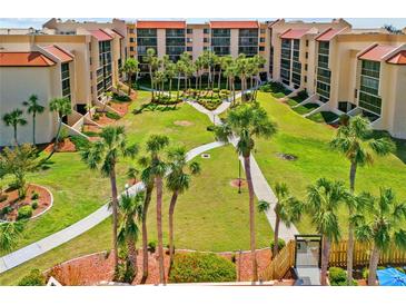 Aerial view of a community featuring palm trees, walking paths, and beautifully landscaped grounds at 3006 Caring Way # 431, Port Charlotte, FL 33952