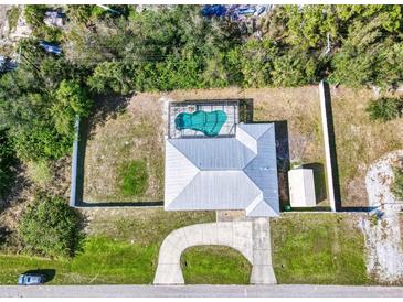 Aerial view of home showcasing a screened pool, fenced yard, shed, and curved driveway at 4520 Knollwood Dr, Punta Gorda, FL 33982
