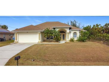 Charming single-story home features an attached garage, well-maintained lawn, and beautiful landscaping at 8054 Loxley Ave, North Port, FL 34291