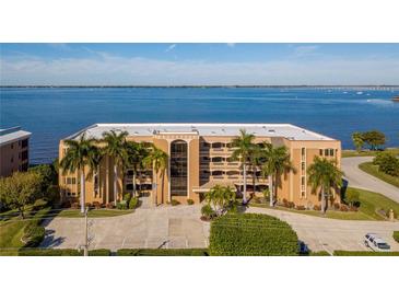 Condo building exterior featuring multiple stories, manicured landscaping, and gorgeous waterfront views at 1601 Park Beach Cir # 112/2, Punta Gorda, FL 33950