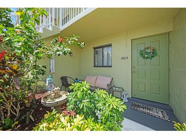 Charming condo front door with garden, seating area, and decorative wreath for a welcoming entrance at 25225 Rampart Blvd # 1604, Punta Gorda, FL 33983