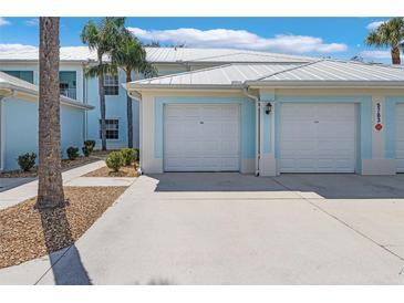 Inviting blue two-story home featuring dual garages and well-maintained landscaping at 5783 Sabal Trace Dr # 103B57, North Port, FL 34287