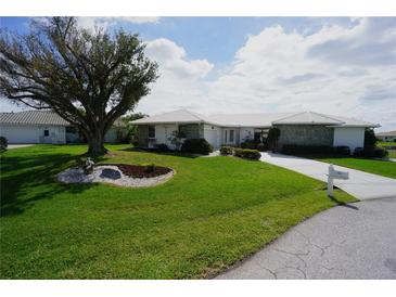 Beautiful one-story home with a stone accent wall, tidy landscaping, and a spacious green lawn at 1407 Waxwing Ct, Punta Gorda, FL 33950