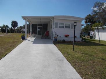 Charming single-story home with a covered porch and well-manicured lawn at 5632 Holiday Park Blvd, North Port, FL 34287