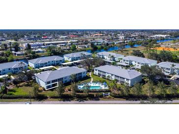 Enjoy the community pool and surrounding waterways in this beautiful aerial view of the complex at 5725 Greenwood Ave # 3104, North Port, FL 34287