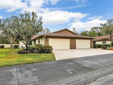 Charming home featuring a two-car garage and nicely landscaped front yard with mature trees at 623 Oak Hill Cir # 28, Sarasota, FL 34232