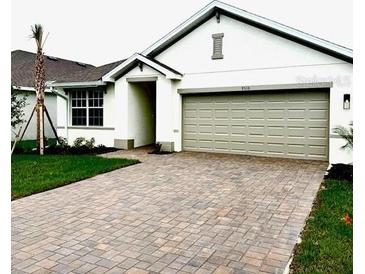 Charming single-Gathering home featuring an attached two-car garage and a beautifully brick-paved driveway at 9516 Turtle Grass Cir, Punta Gorda, FL 33950
