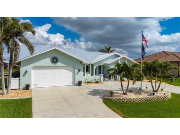 Single-Gathering home showcasing a well-manicured lawn, palm trees, and a spacious driveway at 1334 Via Milanese, Punta Gorda, FL 33950