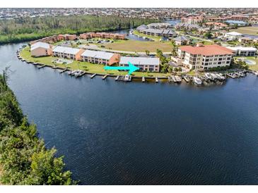 Aerial view of a waterfront condo with boat docks, beautiful landscaping, and lake view at 1344 Rock Dove Ct # D102, Punta Gorda, FL 33950