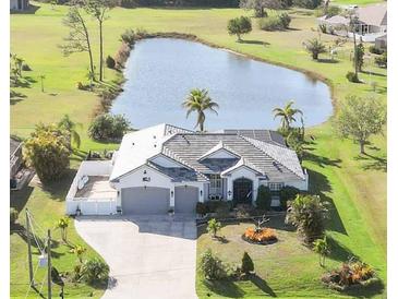 Stunning aerial view of home, landscaped yard, and serene pond providing a peaceful outdoor retreat at 1417 Carswell St, Port Charlotte, FL 33953