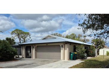 Charming single-story home with a well-maintained lawn, two-car garage and screened front entrance at 22480 Oceanside Ave, Port Charlotte, FL 33952