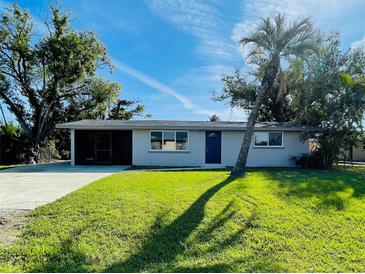 Charming single-story home featuring a well-maintained lawn, palm tree, and a screened entrance at 1625 Meadow Lark Ln, Englewood, FL 34224