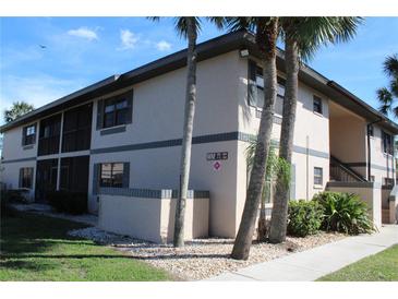 Condo building with a well-maintained exterior and tropical landscaping at 19505 Quesada Ave # Mm202, Port Charlotte, FL 33948