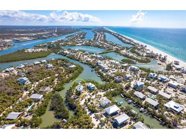High aerial view of waterfront community surrounded by canals and a sandy beach nearby at 20 Palm Dr, Placida, FL 33946