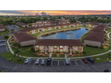 Scenic aerial view of a multi-Gathering home community with a serene pond and lush landscaping at 25100 Sandhill Blvd # R104, Punta Gorda, FL 33983