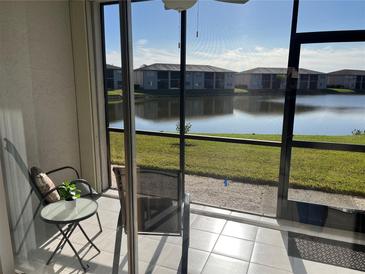 Relaxing lanai with tiled floor and views of the community lake and lush landscaping at 25100 Sandhill Blvd # R104, Punta Gorda, FL 33983