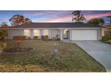 Charming single-story home featuring a well-maintained front yard and attached garage with a long driveway at 3265 Sunrise Trl, Port Charlotte, FL 33952
