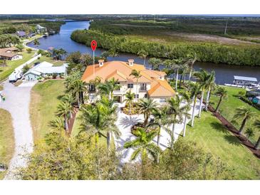 Stunning waterfront estate with lush landscaping, circular driveway, and panoramic views of the river at 7440 Riverside Dr, Punta Gorda, FL 33982