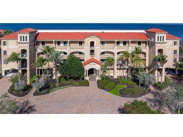 Beautiful Mediterranean-style building with red tile roof, lush landscaping, and inviting entrance at 85 Vivante Blvd # 8542, Punta Gorda, FL 33950