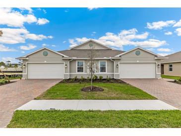 Beautiful exterior view of a modern, two-story home with a manicured lawn and brick paver driveway at 16408 Bridle Ridge St, Port Charlotte, FL 33953