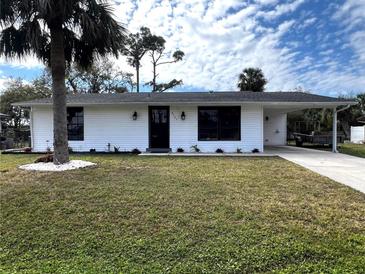 Charming single-story home with a well-maintained lawn, carport, and a freshly painted exterior at 2507 Linton Ln, Port Charlotte, FL 33952