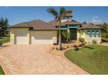 Lovely Florida home with a three-car garage, well-manicured lawn, and brick driveway at 9149 Lane Ct, Port Charlotte, FL 33981