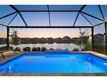 Screened pool with lake view and string lights at 10112 Canaveral Cir, Sarasota, FL 34241