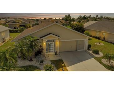 Charming single-story home featuring a well-manicured lawn and inviting front entrance at sunset at 1944 Boddington Trl, Port Charlotte, FL 33980