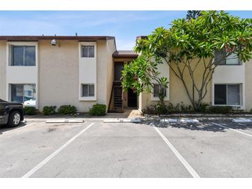 Condo exterior featuring stairs to the units, parking, and green landscaping with a mature tree at 2717 Hidden Lake Blvd # C, Sarasota, FL 34237