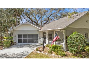 Charming single-story home with a well-maintained lawn, screened porch, and a two-car garage at 1350 Old Oak Trl, Port Charlotte, FL 33948