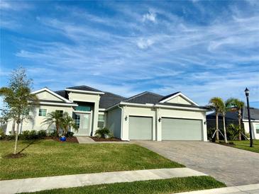 Stunning home with manicured lawn, gray paint, black roof, and an oversized, attached two car garage at 15155 Scarlet Oak Ct, Punta Gorda, FL 33955