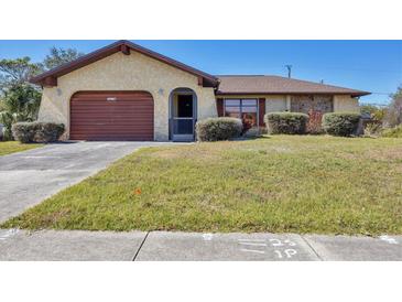 Charming single-story home with a well-maintained front lawn and covered entry at 19874 Midway Blvd, Port Charlotte, FL 33948