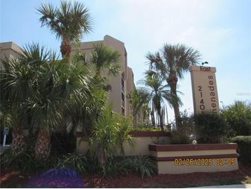 View of the exterior with mature landscaping and signage at the East Promenades complex at 21405 Olean Blvd # 605, Port Charlotte, FL 33952