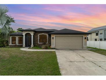 Charming single-story home with stone accents, manicured lawn, and a two-car garage at 23283 Duchess Ave, Port Charlotte, FL 33954