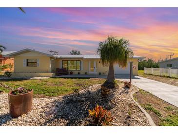 Inviting single-story home featuring a lush landscaped yard and charming curb appeal at sunset at 3100 Magnolia Way, Punta Gorda, FL 33950