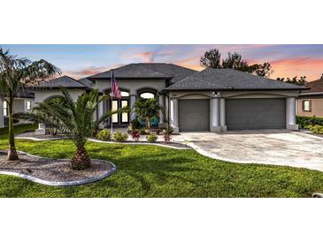 Stunning home showcasing a manicured lawn, fresh landscaping, and a two-car garage at 664 Rotonda Cir, Rotonda West, FL 33947