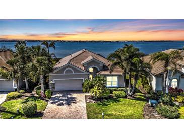 Beautiful single-story home with tropical landscaping and sunset water views at 12905 N Marsh Dr, Port Charlotte, FL 33953