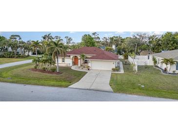 Charming single-story home features a well-maintained lawn, landscaping, and a two-car garage at 23488 Almond Ave, Port Charlotte, FL 33954