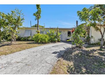 Charming single-story home with a well-maintained lawn and a paved driveway leading to the entrance at 2440 Ednor St, Port Charlotte, FL 33952