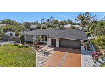 Beautiful single-story home boasts manicured lawn, stone accents, and unique brick-designed driveway at 20343 Rutherford Ave, Port Charlotte, FL 33952
