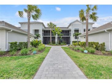Beautiful building exterior, manicured landscaping, sidewalks, and palm trees at 15970 Grassland Ln # 2816, Punta Gorda, FL 33982