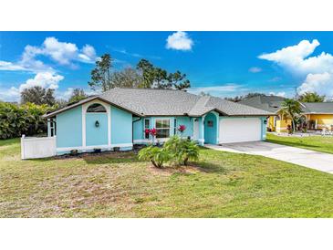 Charming light blue single Gathering home featuring a two-car garage and well-manicured lawn at 25069 Bolivar Dr, Punta Gorda, FL 33983