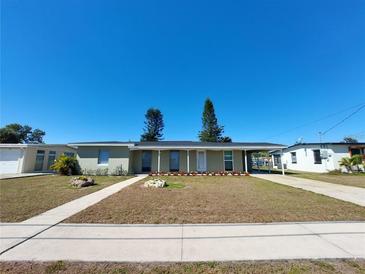 Charming single-story home featuring a well-maintained lawn and covered parking area at 4045 Conway Blvd, Port Charlotte, FL 33952