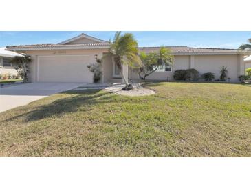Charming single-story home with a well-manicured lawn and tropical landscaping, creating curb appeal at 944 Genoa Ct, Punta Gorda, FL 33950